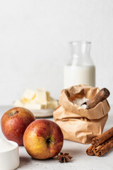 Baking ingredients for homemade apple cake or pie: flour, eggs, milk, sugar, butter and spices on white background with copy space