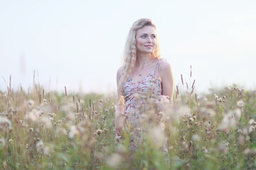 romantic girl posing in a summer field dress