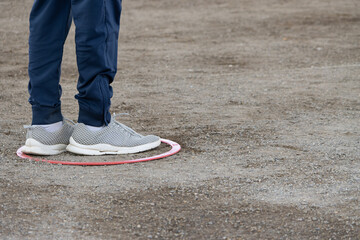 A petanque player in the circle from where the steel balls are thrown, trying to get the boule as...