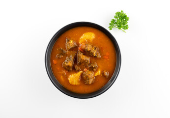 Traditional Hungarian cuisine. Thick Hungarian soup - beef goulash, paprika, carrots and potatoes on a white plate macro..