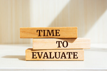 Wooden blocks with words 'TIME TO EVALUATE'.