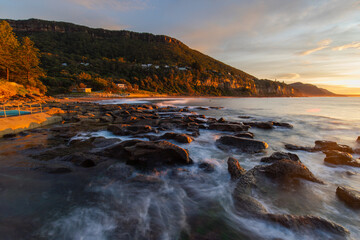 Sunrise view at the rocky beach shore.
