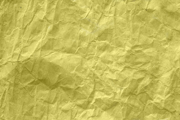 High detail of the abstract texture of the packaging paper. The texture of crumpled yellow craft paper. Crumpled yellow paper background top view. The texture of crumpled yellow paper.