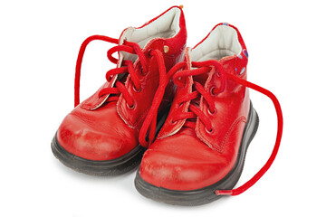 Worn out kiddie-size red lace-ups. Children's shoes with laces. Old ankle boots for small kid.