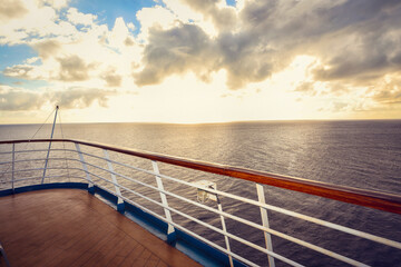 Wooden deck and railing from cruise ship. Beautiful sunset and ocean view.