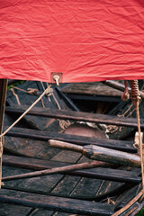 Medieval wooden ship, sailboat with a red sail. Reconstruction of the events of the Middle Ages in Europe. with the phoenix bird