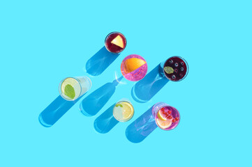 Colorful cocktails with fruit and mint on a blue background. Summer aesthetic trendy refreshing drink.