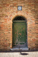 Antique green door in Urbino, a medieval town in the Marche region of Italy