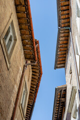 A narrow street with houses in bricks in Urbino a medieval town of the Marche region of Italy