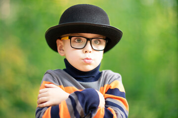 Boy as a movie actor or showbiz star. Black hat and striped