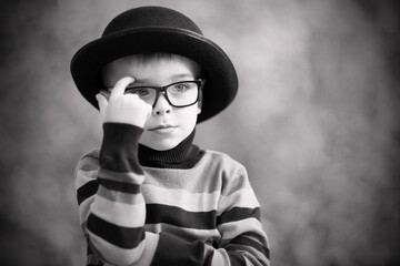 Boy as a movie actor or showbiz star. Black hat and striped