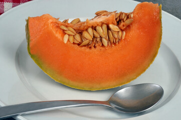 Tranche de melon tranché dans une assiette avec une cuillère