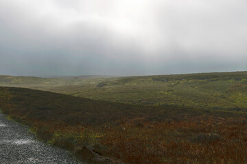 Small country road and cloudy skies out of focus in the background, travel and tourism concept, rural autumn landscape