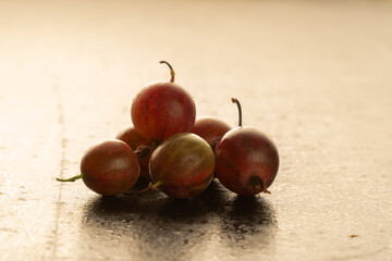 Still life food: green gooseberries on black wooden background