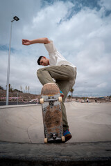 young skater makes a trick called "blunt Fakie" in a skatepark. vertical composition © magui RF