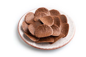 Chocolate chips isolated on white background. side view, close up.