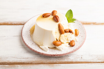 Ricotta cheese with honey and almonds on white wooden. side view, close up.