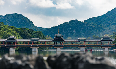 Naklejka premium An ancient bridge over a lake in a park in the South of China
