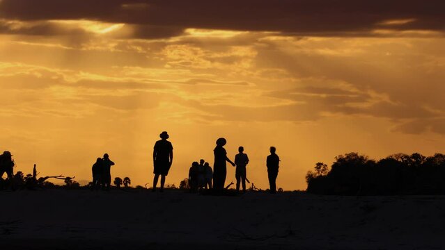 Tourists walk along a sandbank along the Rufiji River in southern Tanzania, East Africa