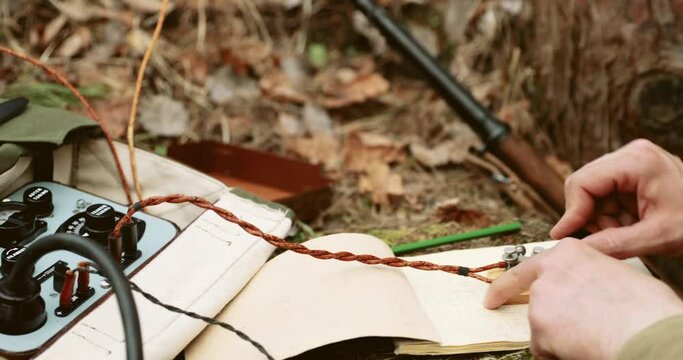 Russian Soviet Infantry Red Army Soldier In World War II using Russian Soviet Portable Radio Transceiver In Trench Entrenchment In Spring Autumn Forest. 4K. Headphones And Telegraph Key. Close Up
