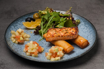 grilled salmon with french fries, salad, side dish of salmon with cucumber