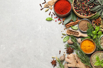 Different herbs and spices on grey table, flat lay. Space for text