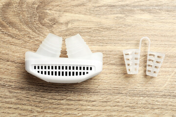 Different anti-snoring devices for nose on wooden table, flat lay