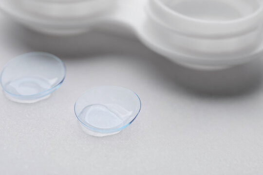 Contact lenses and case on white background, closeup