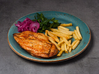 grilled chicken fillet with french fries, red onion and herbs