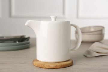 Ceramic teapot on wooden table. Clean dishware