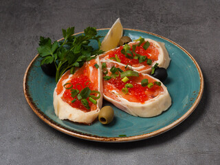 pancake rolls with salmon and red caviar, decorated with green onions