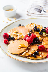 Summer homemade pancakes with raspberries, currants and peanut butter.