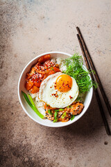 Bibimbap - meat, rice, kimchi, egg and sprouts in white bowl. Traditional Korean food.