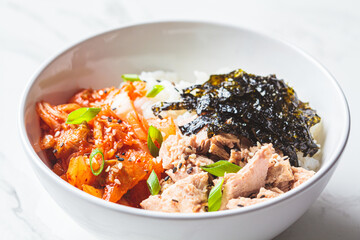 Kimchi tuna rice salad in white bowl. Traditional Korean food.