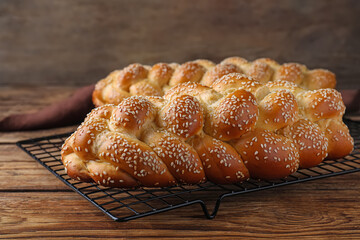 Homemade braided breads with sesame seeds on wooden table, closeup. Challah for Shabbat