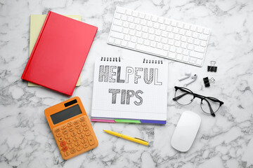Flat lay composition with text Helpful Tips in notebook on white marble table