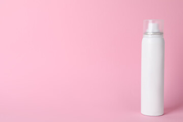 Bottle of dry shampoo on pink background, space for text