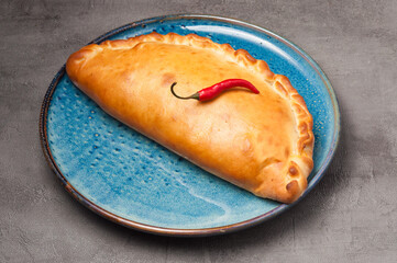 traditional Italian pizza calzone decorated with chili pepper