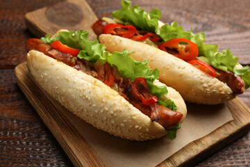 Tasty hot dogs on wooden table, closeup. Fast food