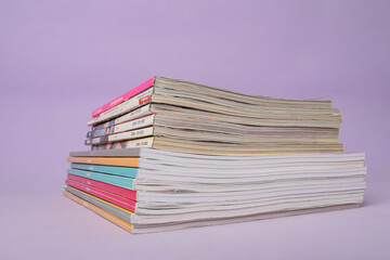 Group of stacked magazines on violet background