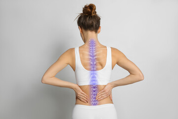 Woman with healthy spine on light background, back view