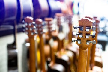 Selective focus to guitar tuning knob with blurry  many guitar in musical showroom at musical...