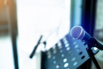 Microphone with blurry musician's lectern or music stand in music studio.