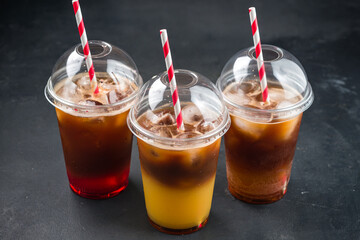 Various iced layered coffee drinks with orange juice and syrups