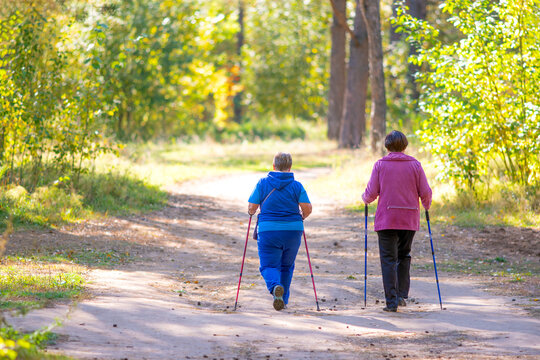Two senior women are doing scandinavian walk.