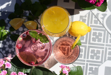 Fototapeta na wymiar Mango, strawberry cocktails and rose lemonade on a garden table. Summer cocktails close up photo. Refreshing drinks in different glasses. 