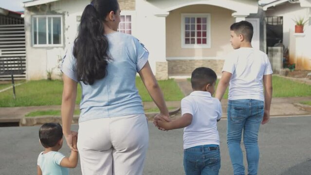 Latino family walking down the street with their backs