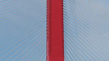 Close up of the structural lines of the bridge under the blue sky, symmetrical steel construction.