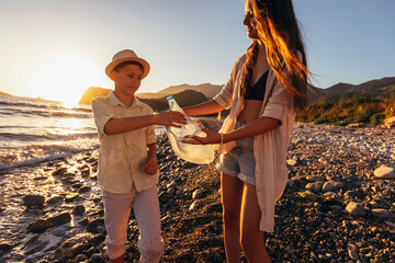 Environment concept. Children volunteers picking up trash on the beach