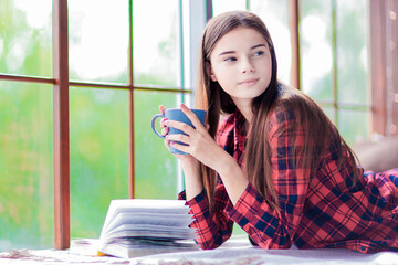 A cute teen girl with a cunning look having morning coffee.